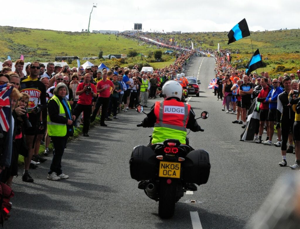 Motorbike Judge driving through the crowds lining the roads on Dartmoor