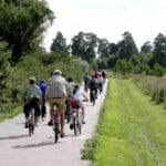 Group of adults and children riding along a cycle path